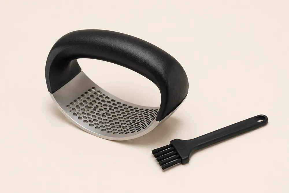 Presse-ail à bascule posé à côté de sa petite brosse de nettoyage noire