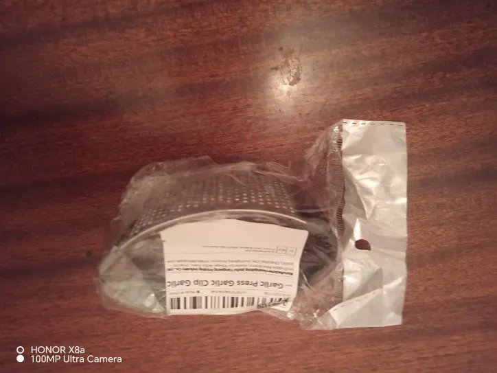 Presse-ail inox posé à côté de gousses d'ail — photo d'un acheteur vérifié