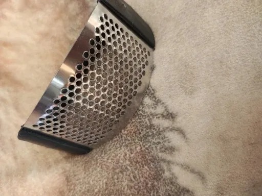 Plaque perforée bombée en inox d'un presse-ail à bascule — photo d'un acheteur vérifié
